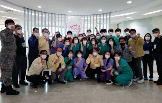 22일 코로나19 생활치료센터 지원임무가 완료된 LG디스플레이 구미 동락원에서 장세용(앞줄 왼쪽 두번째) 구미시장, 권영진(앞줄 왼쪽 다섯번째) 대구시장, 의료진, 대구경북 관계자들이 기념촬영을 하고 있다. <LG디스플레이 제공>